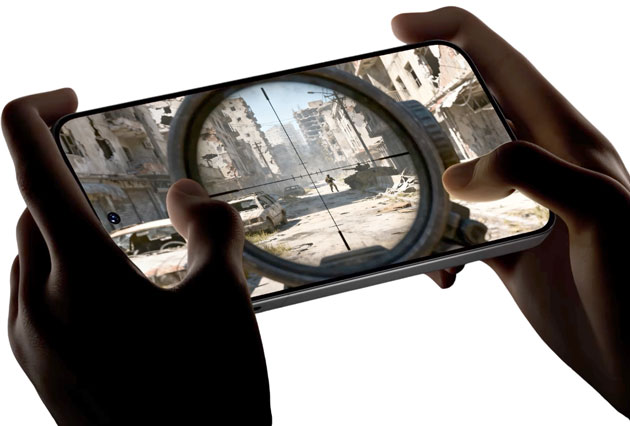 First-person perspective of hands holding the iQOO 15 Ultra in landscape mode while playing a graphically intensive shooter game.