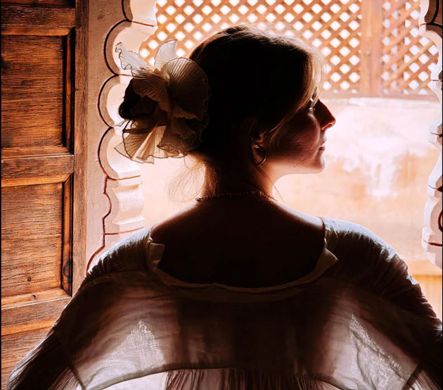 A high contrast indoor portrait captured on the Xiaomi 15 Ultra featuring a woman looking out through a decorative arched window A high-contrast indoor portrait captured on the Xiaomi 15 Ultra, featuring a woman looking out through a decorative arched window.