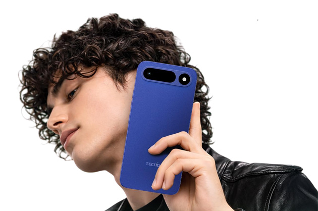 A person with curly hair wearing a black leather jacket holding the Tecno Pop X Midnight Blue smartphone near their face A person with curly hair wearing a black leather jacket, holding the Tecno Pop X Midnight Blue smartphone near their face.