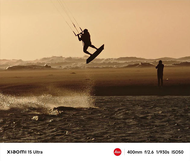 A photo of a kiteboarder in silhouette at sunset taken with a focal length of 400mm on the Xiaomi 15 Ultra A photo of a kiteboarder in silhouette at sunset, taken with a focal length of 400mm on the Xiaomi 15 Ultra.