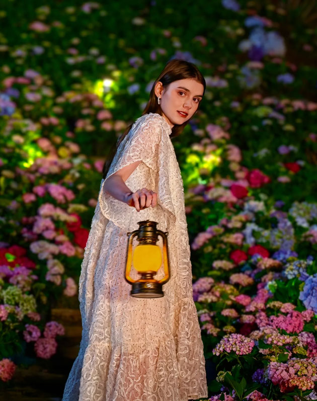 Huawei Pura 80 Ultra night portrait showing a woman with a lantern in a blooming hydrangea garden Huawei Pura 80 Ultra night portrait showing a woman with a lantern in a blooming hydrangea garden.