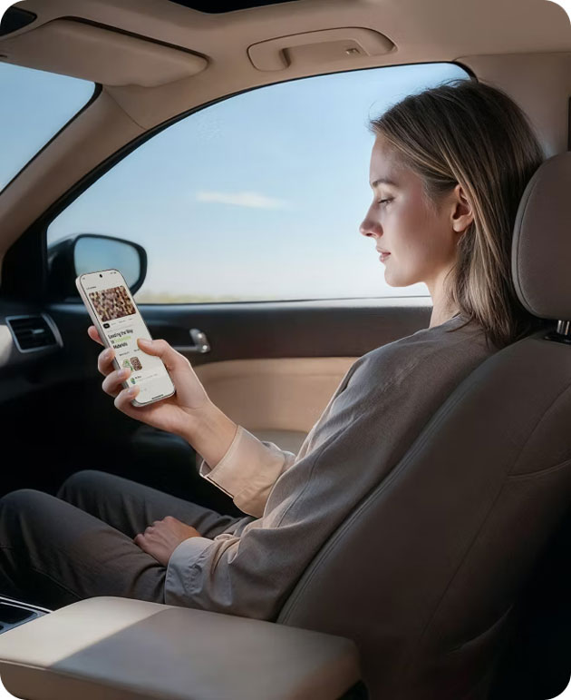 A person sitting in the passenger seat of a car holding and looking at the Honor 600 Pro A person sitting in the passenger seat of a car, holding and looking at the Honor 600 Pro.