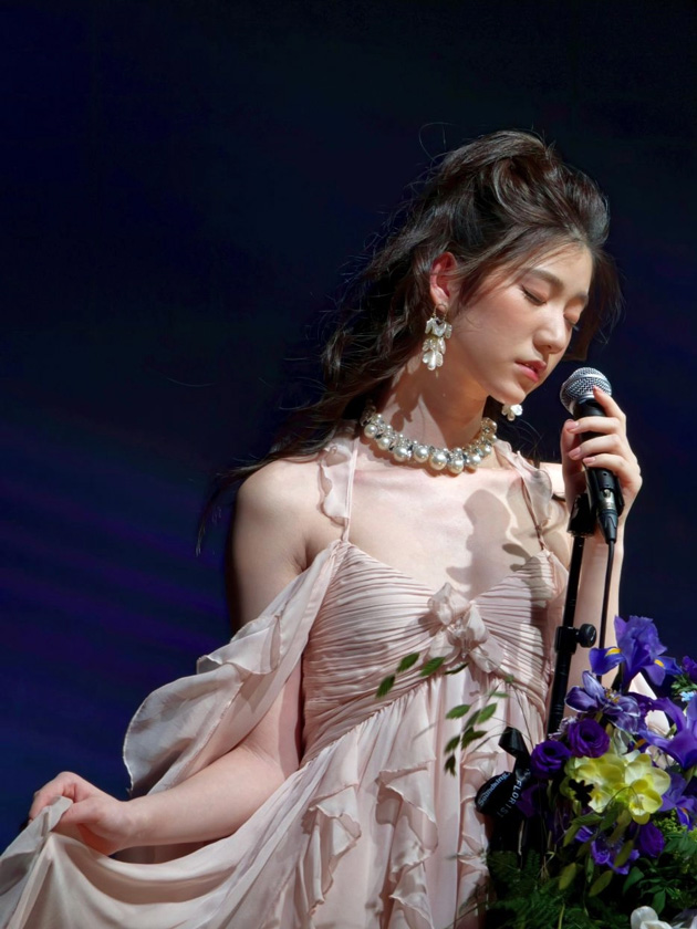 A portrait on stage in a pink outfit with a bouquet; taken with the OPPO Find X9 Ultra camera