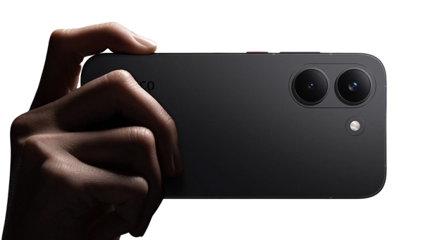 Hand holding a black Poco X8 Pro from the back, showing the dual-camera setup.