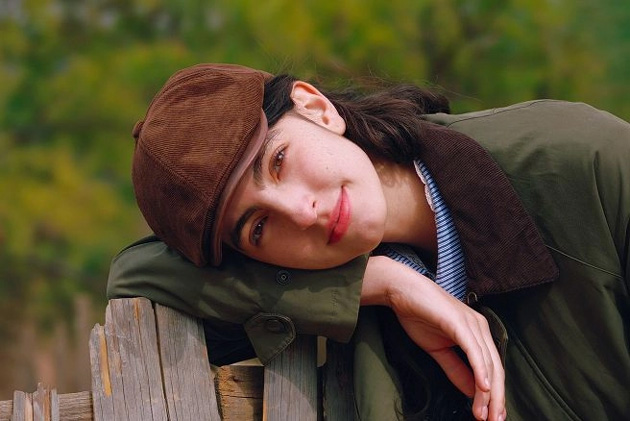 Image of a person leaning on a wooden railing, captured with high quality by the OPPO Find X9 Ultra camera, demonstrating the phone’s ability to capture details and natural ambient colors