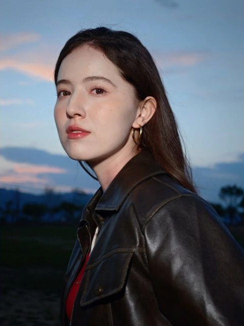 Outdoor close-up profile with blue sky and dark leather jacket background; photo taken with OPPO Find X9 Ultra camera