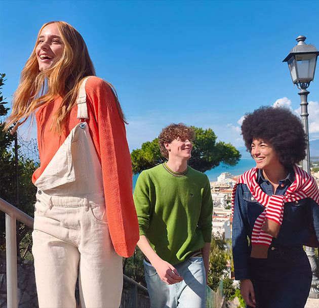 A photo shot on the Xiaomi Redmi Note 15 Pro 5G featuring three young people walking down the steps on a sunny day with the sea in the background A photo shot on the Xiaomi Redmi Note 15 Pro 5G featuring three young people walking down the steps on a sunny day with the sea in the background.