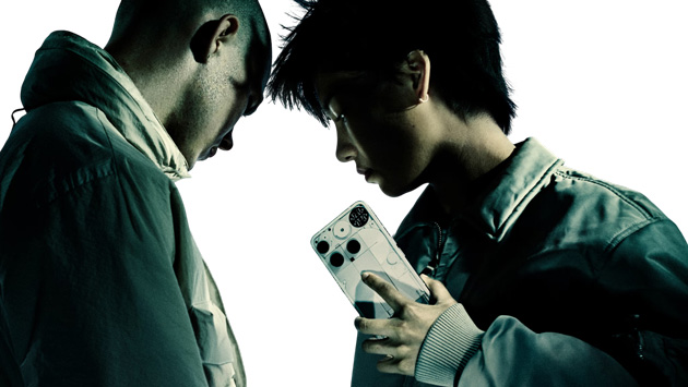 Dramatic profile view of two models with a modern style against a white background while ones holding the Nothing Phone 3 White Dramatic profile view of two models with a modern style against a white background, while one's holding the Nothing Phone (3) White.